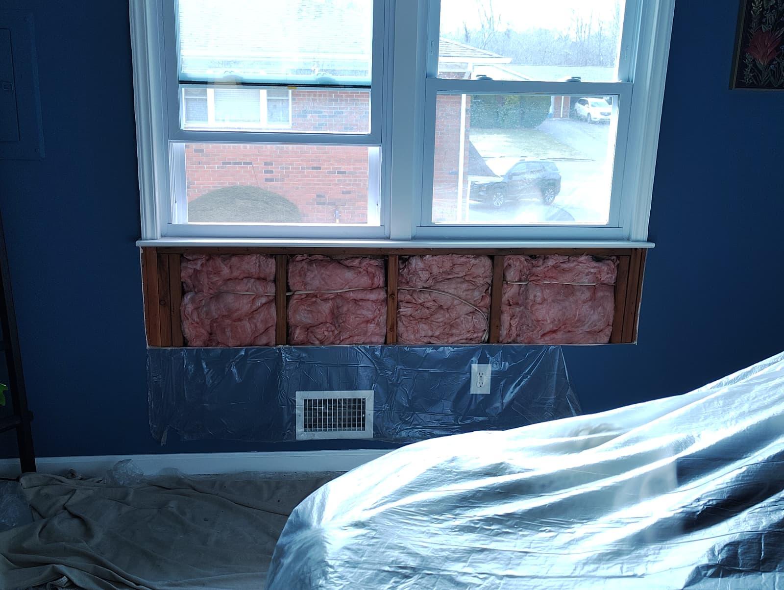 New clean insulation installed in the wall cavity below the window