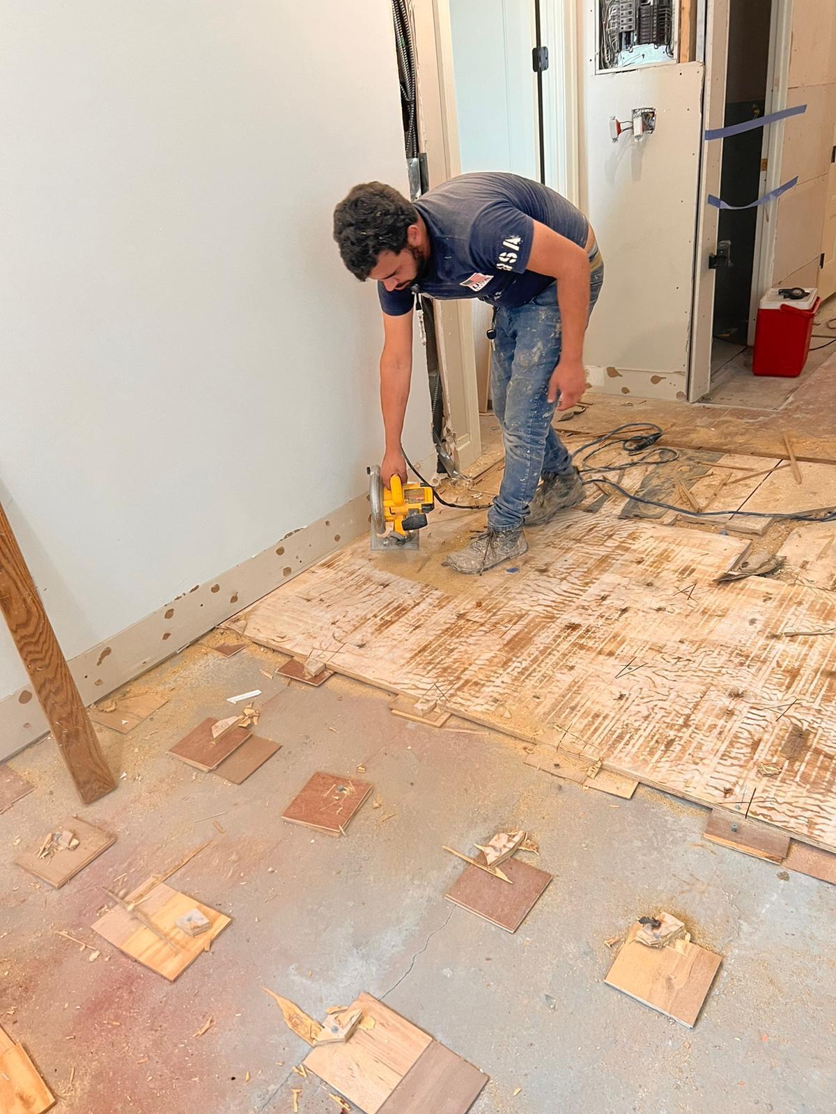 Removing old flooring and preparing the plywood subfloor with a circular saw